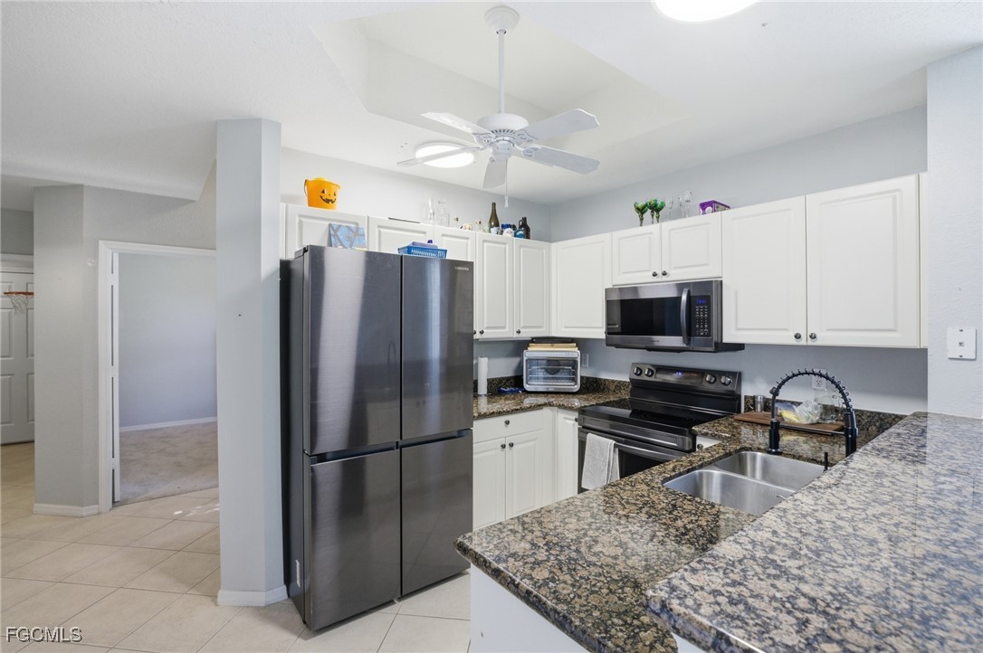13160 Broadhurst Loop, Unit 101 Fort Myers, FL 33919 - Photo 11 of 39 a kitchen with stainless steel appliances granite countertop a refrigerator a stove top oven a sink and dishwasher