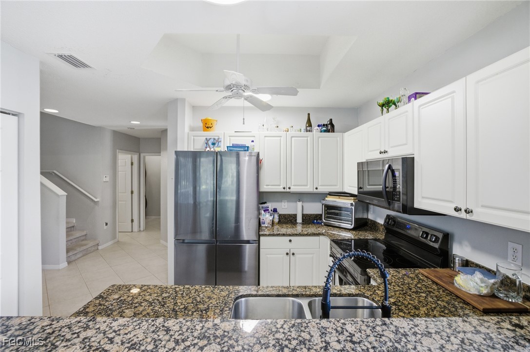 13160 Broadhurst Loop, Unit 101 Fort Myers, FL 33919 - Photo 12 of 39 a kitchen with stainless steel appliances granite countertop a refrigerator sink and stove