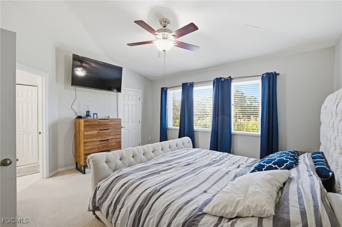 13160 Broadhurst Loop, Unit 101 Fort Myers, FL 33919 - Photo 19 of 39 a bedroom with a large bed and a flat screen tv