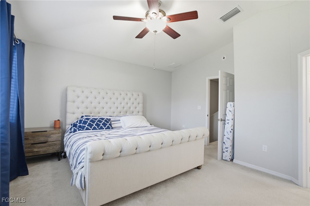 13160 Broadhurst Loop, Unit 101 Fort Myers, FL 33919 - Photo 21 of 39 a bedroom with a bed and a ceiling fan