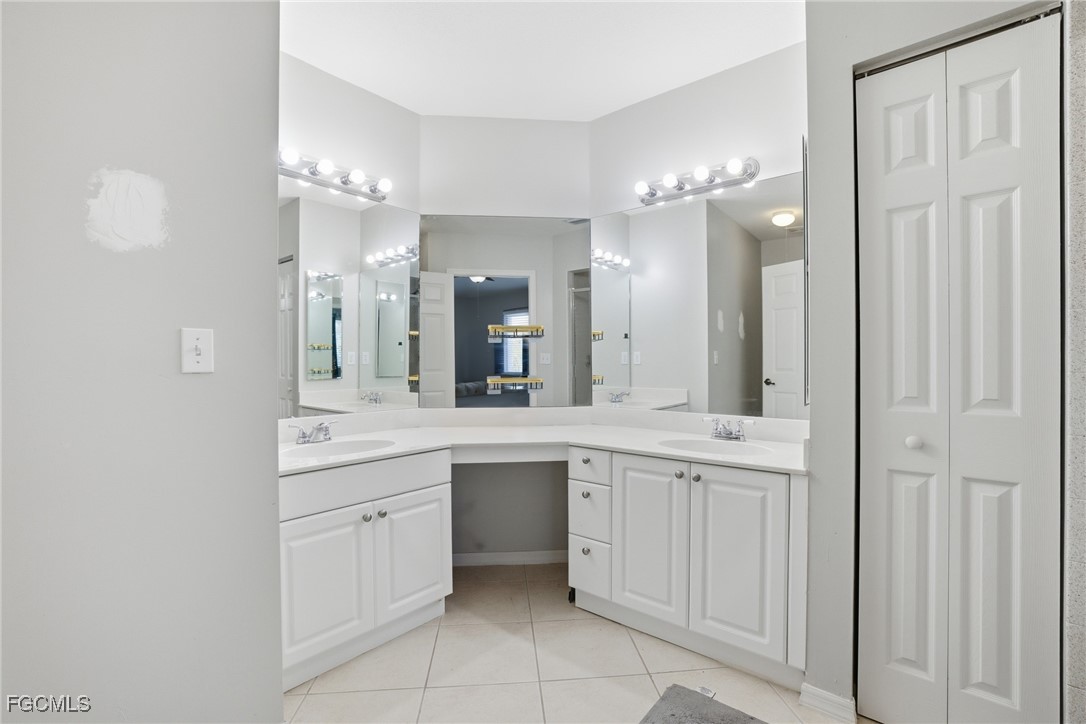 13160 Broadhurst Loop, Unit 101 Fort Myers, FL 33919 - Photo 23 of 39 a large bathroom with a double vanity sink and a mirror