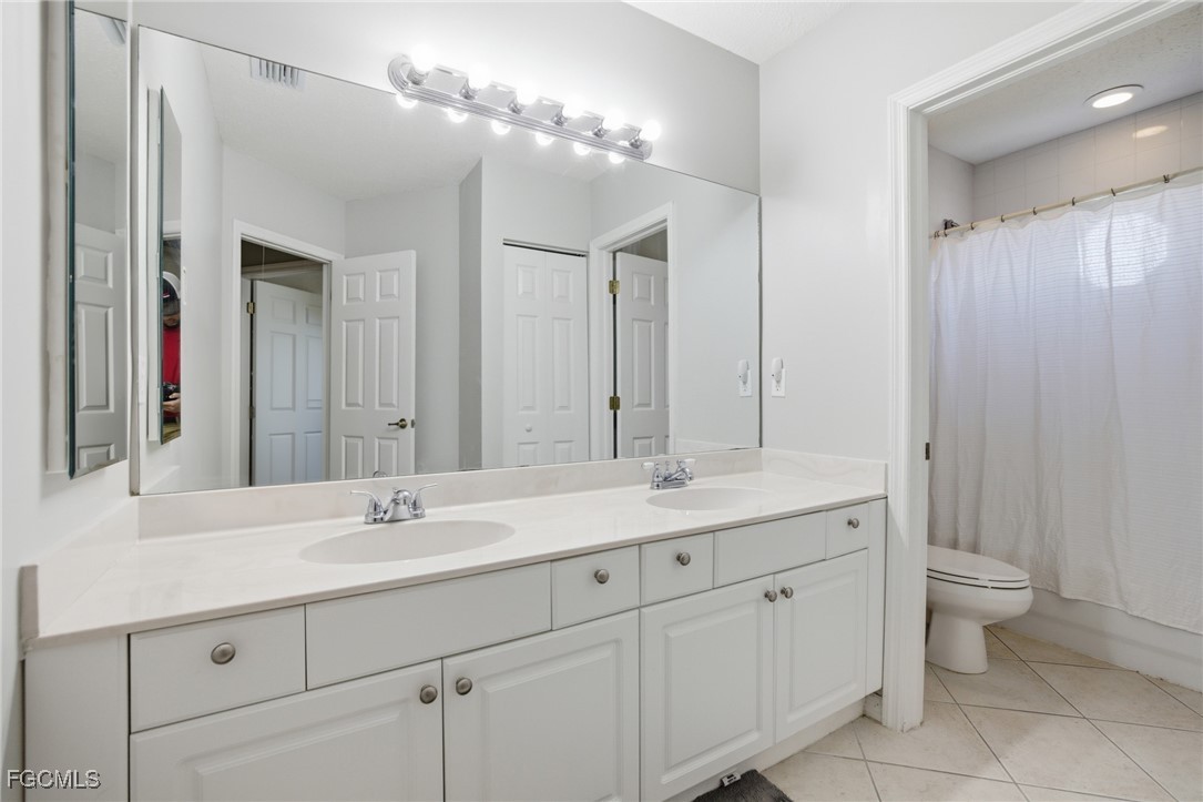 13160 Broadhurst Loop, Unit 101 Fort Myers, FL 33919 - Photo 27 of 39 a bathroom with a double vanity sink and a mirror