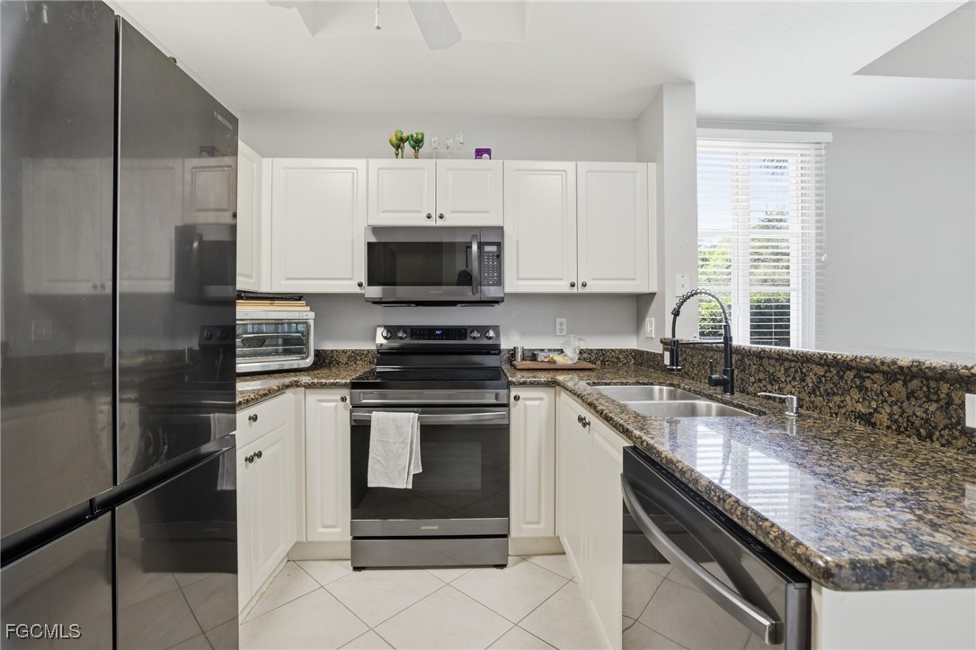 13160 Broadhurst Loop, Unit 101 Fort Myers, FL 33919 - Photo 9 of 39 a kitchen with a sink stove top oven and refrigerator