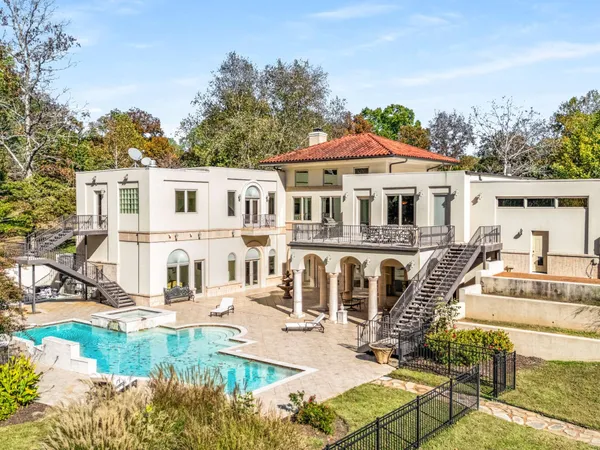 a view of a white house with swimming pool and sitting area