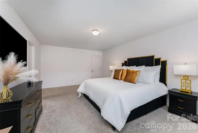 a large bedroom with a bed and flat screen tv