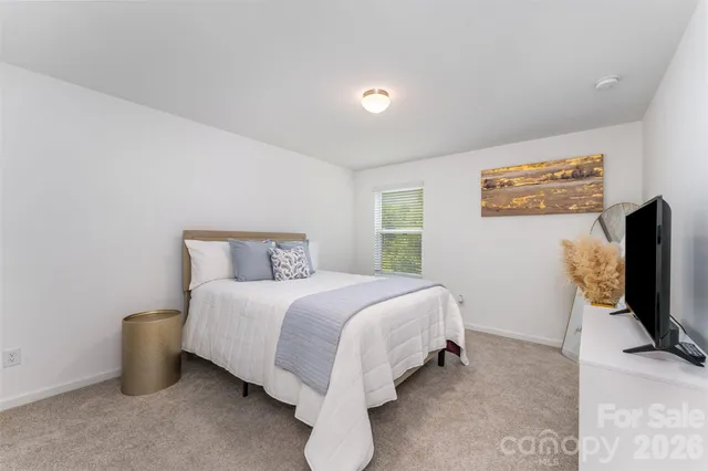 a bed room with a bed tv tv and a window