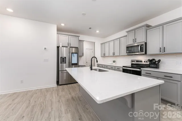 a large kitchen with cabinets stove and refrigerator