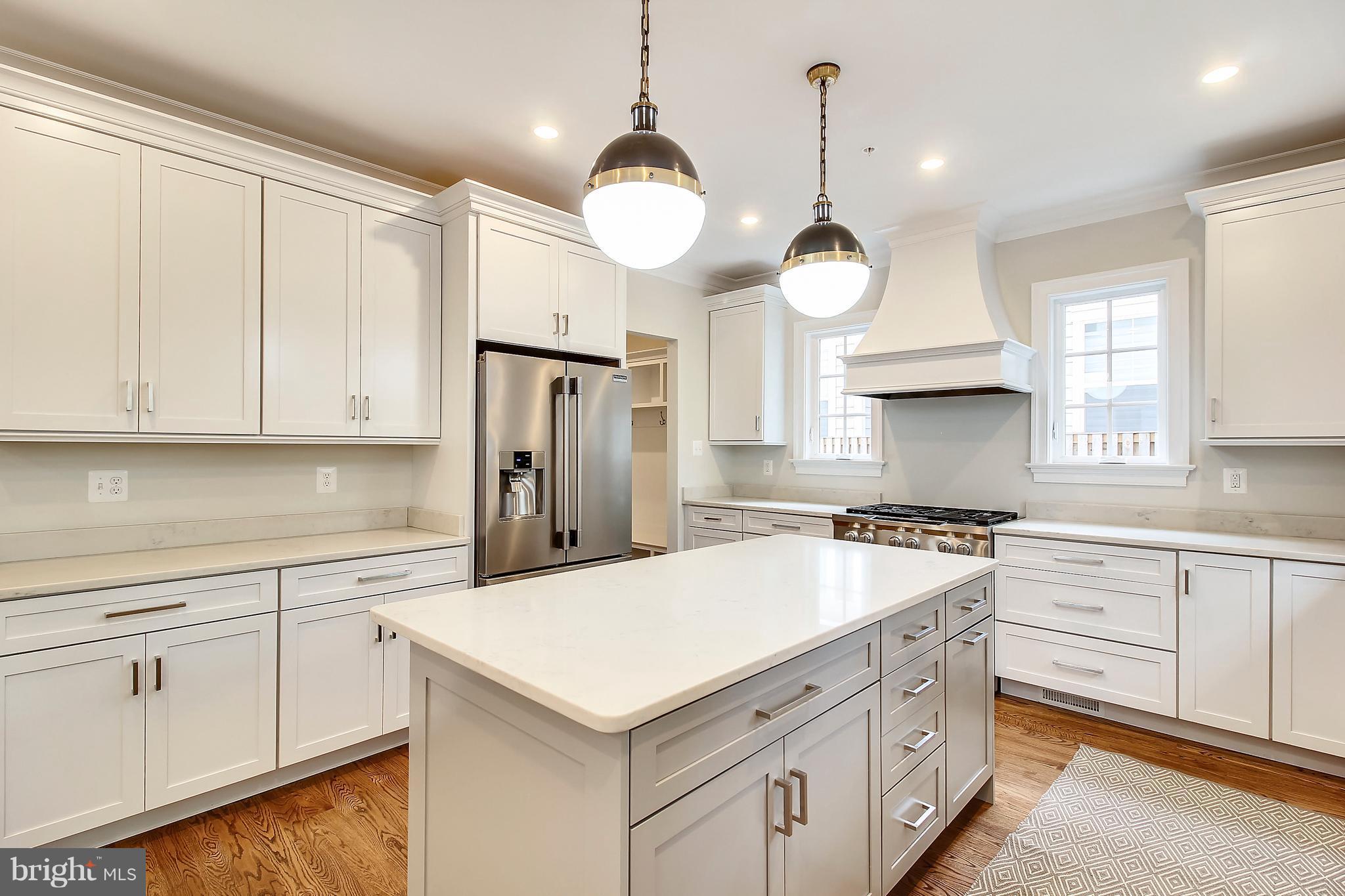 a kitchen with white cabinets and chandelier