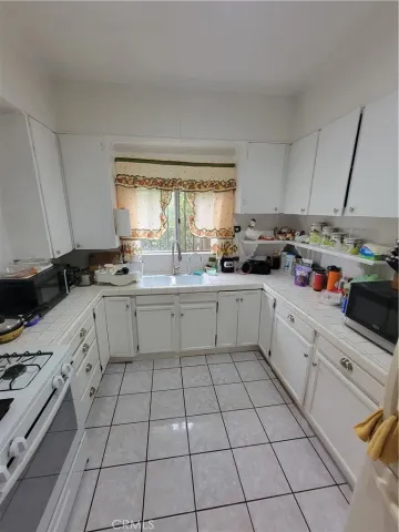 a kitchen with a sink a stove cabinets and counter space