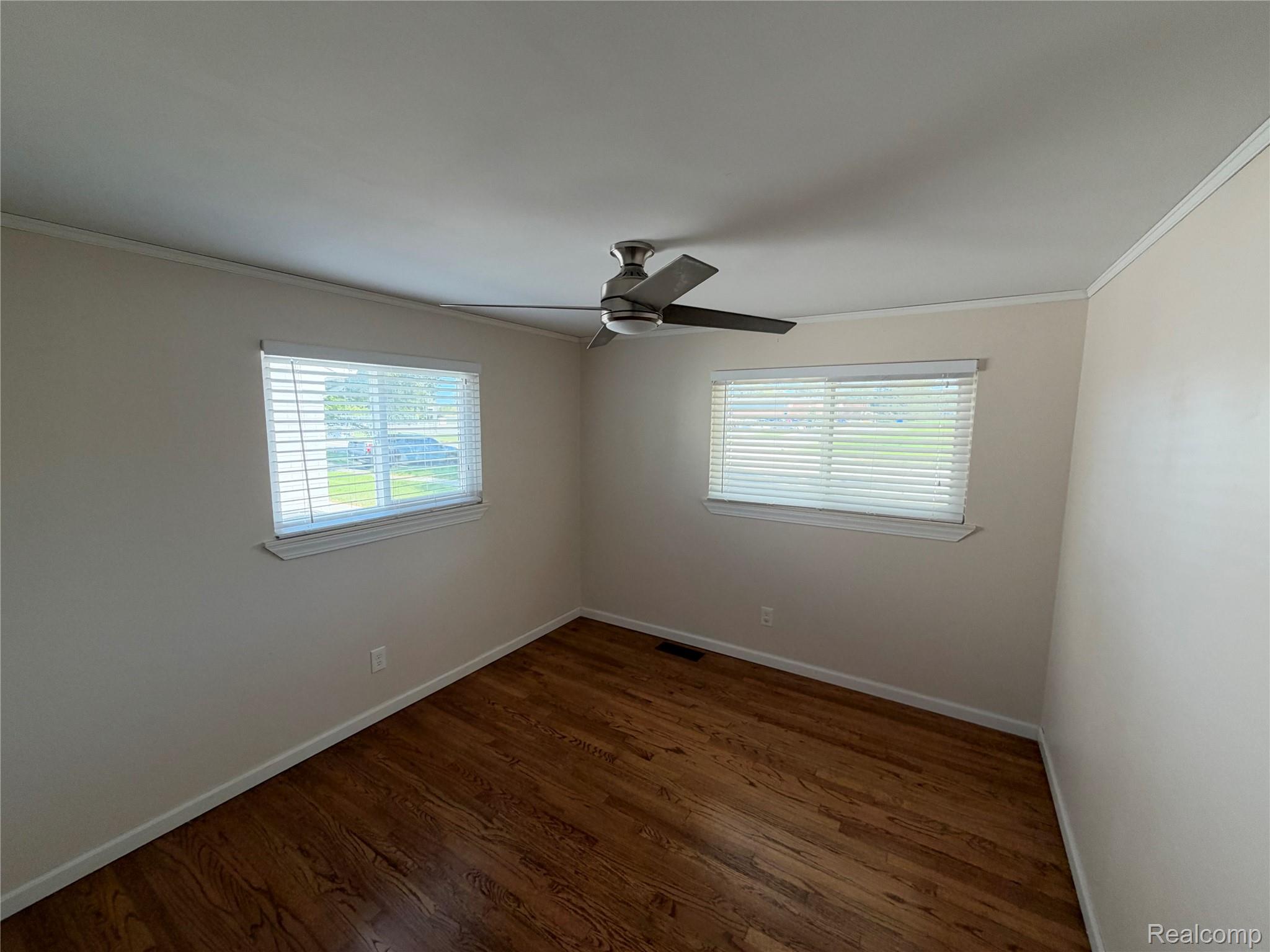 14629 Newburgh Road Livonia, MI 48154 - Photo 16 of 27 Wood-finish flooring, two windows with blinds, and a ceiling fan with integrated lighting