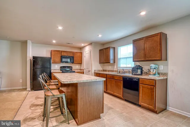 a kitchen with stainless steel appliances granite countertop sink stove top oven and cabinets