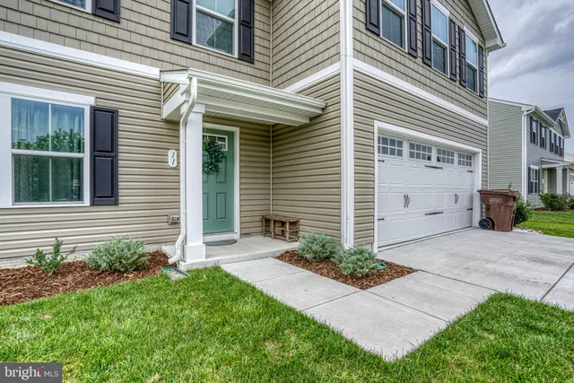 a view of a house with brick walls and a yard with plants