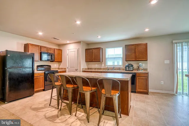 a kitchen with stainless steel appliances granite countertop a table and chairs