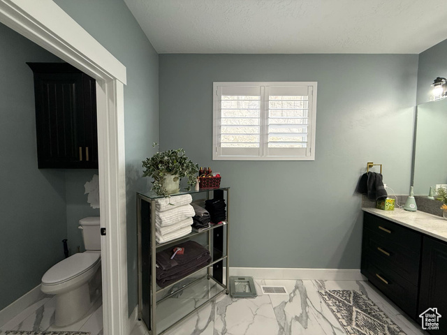 1240 West 2360 North Helper, UT 84526 - Photo 34 of 79 Bathroom featuring toilet, vanity, marble finish floor, baseboards, and visible vents