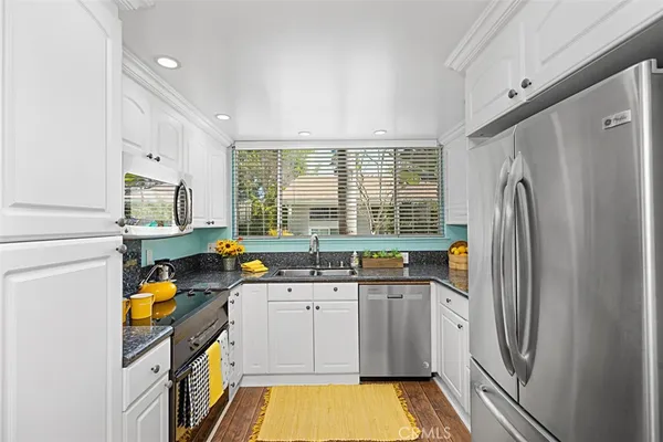 a kitchen with stainless steel appliances granite countertop a sink stove and cabinets