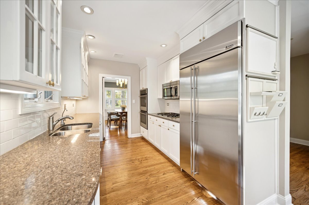 305 Poplar Street Winnetka, IL 60093 - Photo 11 of 26 a large kitchen with kitchen island a counter top space a refrigerator a sink a stove and cabinets