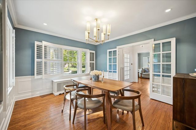 a dining room with furniture window and wooden floor