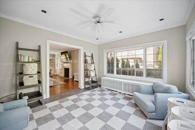 a living room with a large window and a chandelier
