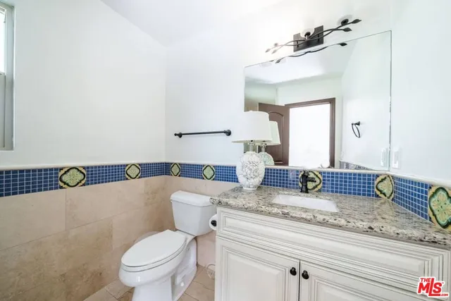 a kitchen with granite countertop a sink stainless steel appliances and white cabinets