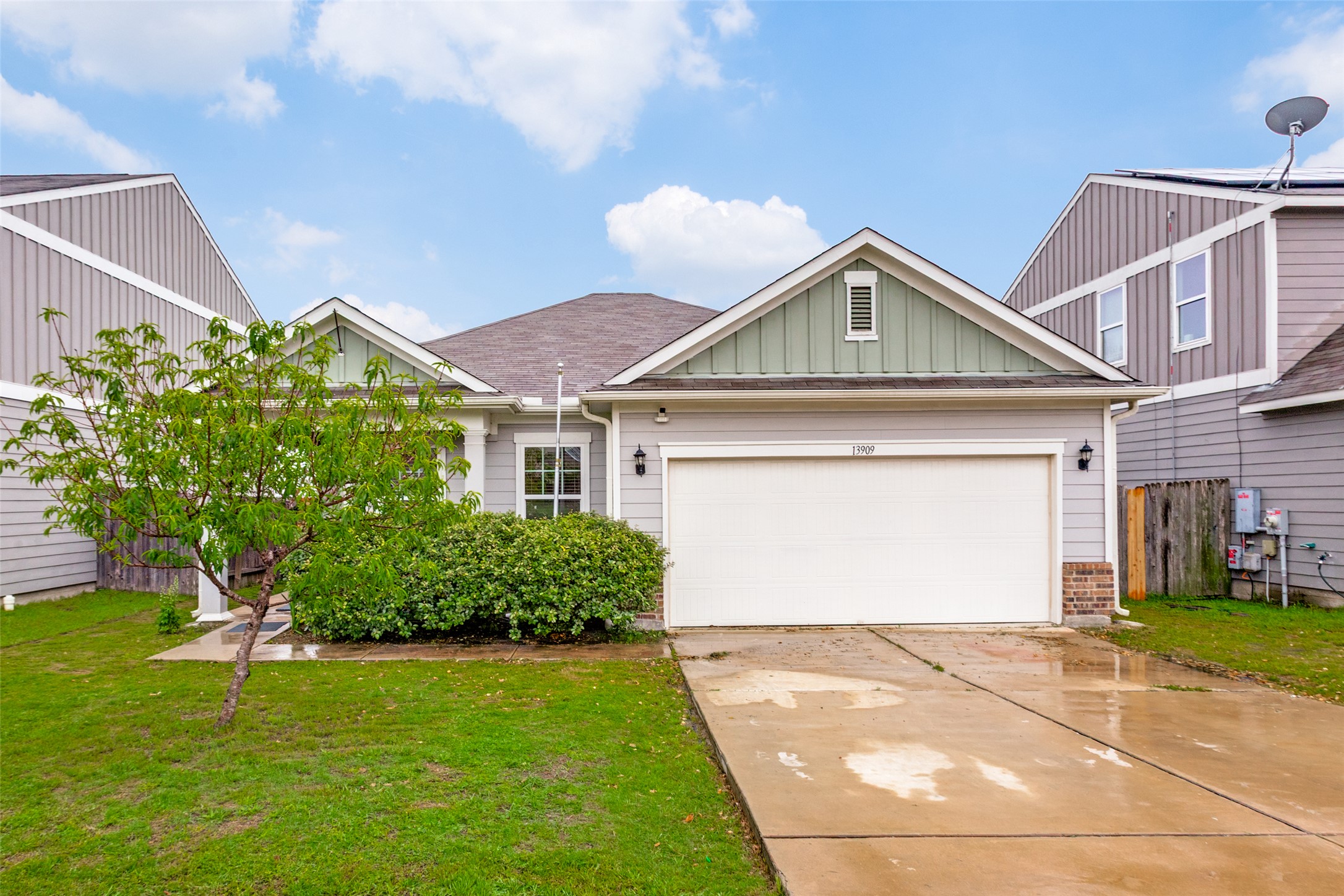Light gray siding exterior with sage green gables and brick accents