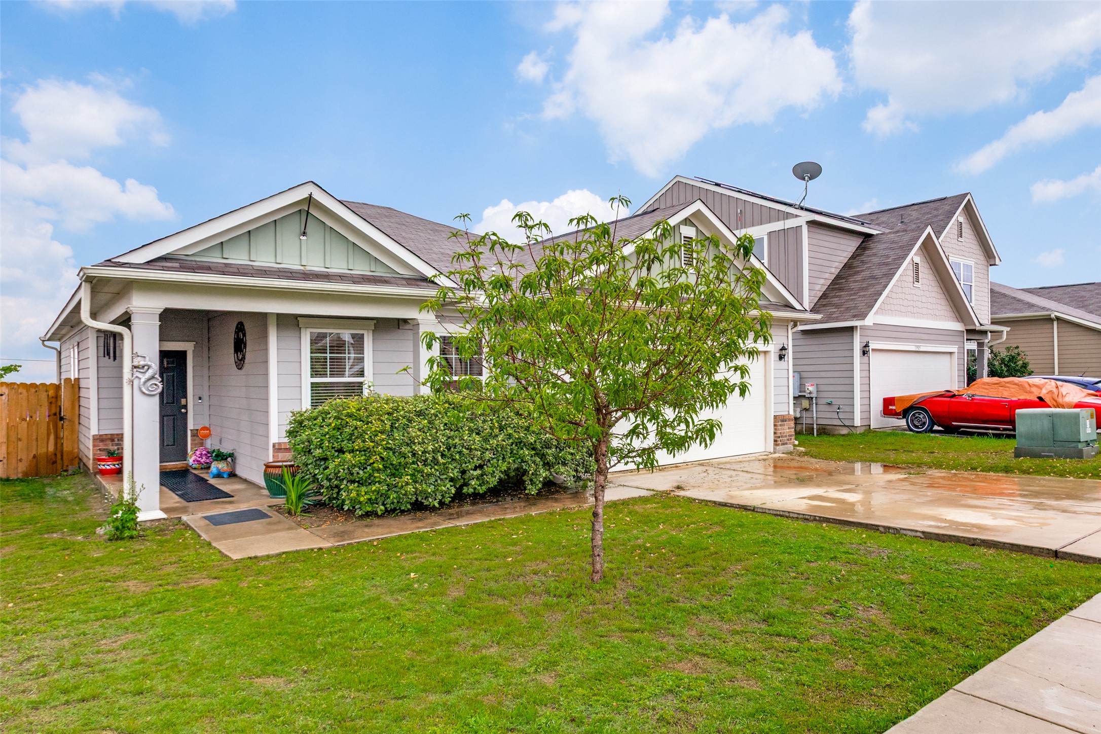 13909 Sherri Berry Way Manor, TX 78653 - Photo 2 of 28 Contemporary exterior with light gray siding, a covered porch, and an attached garage