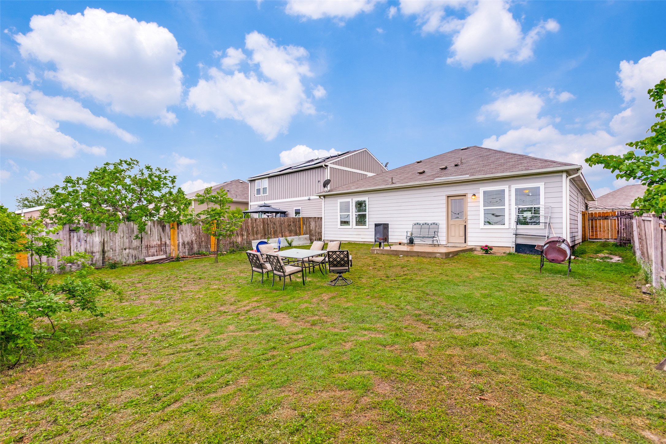 13909 Sherri Berry Way Manor, TX 78653 - Photo 23 of 28 Spacious backyard featuring a grass lawn, wood fencing, and a concrete patio