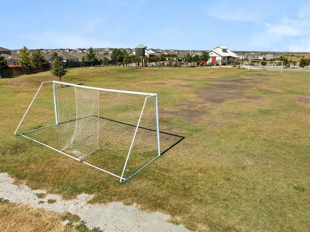 13909 Sherri Berry Way Manor, TX 78653 - Photo 27 of 28 Expansive green space featuring a soccer goal and a distant residential community