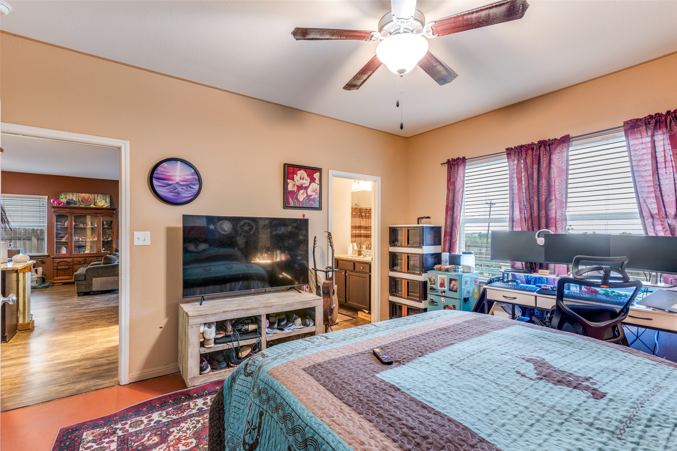 13909 Sherri Berry Way Manor, TX 78653 - Photo 10 of 28 Spacious bedroom featuring light neutral wall paint, a ceiling fan with light fixture, and two large windows with horizontal blinds