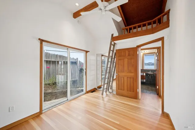 a view of a room with wooden floor and door