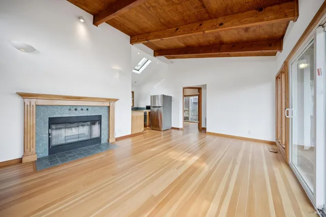 a view of empty room with wooden floor and fireplace