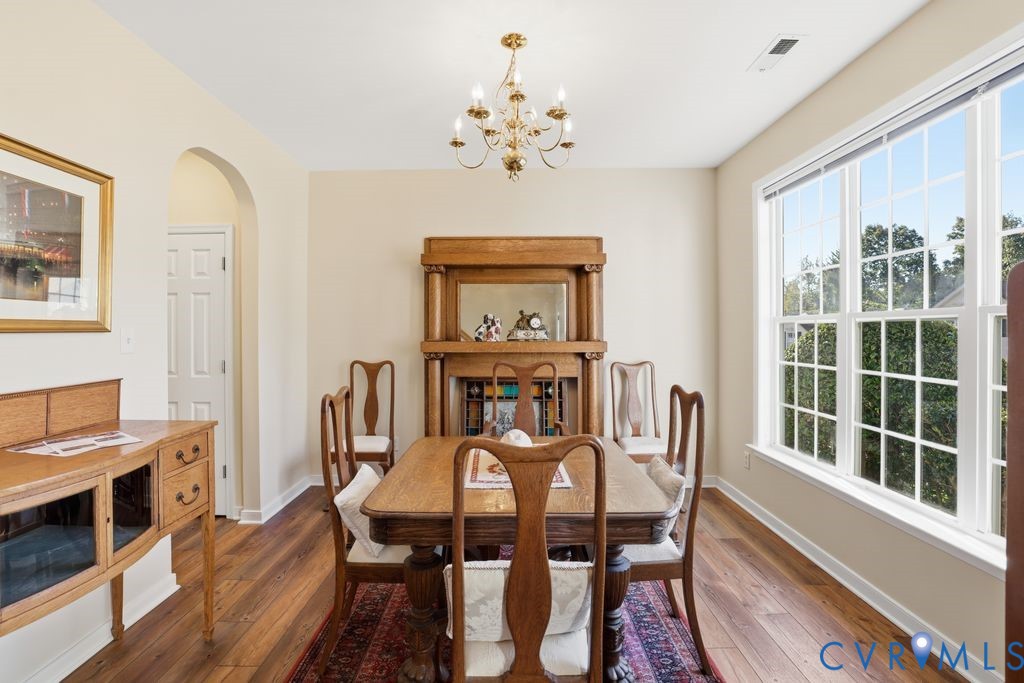 13924 Krim Point Road Midlothian, VA 23114 - Photo 15 of 48 a view of a dining room with furniture a chandelier and wooden floor