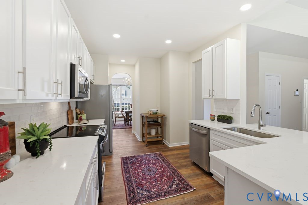 13924 Krim Point Road Midlothian, VA 23114 - Photo 5 of 48 a living room with stainless steel appliances furniture a rug and a kitchen view