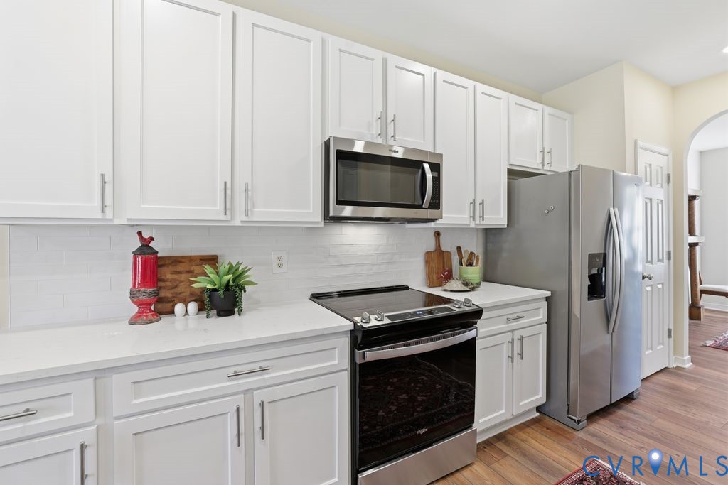 13924 Krim Point Road Midlothian, VA 23114 - Photo 6 of 48 a kitchen with stainless steel appliances granite countertop white cabinets a refrigerator and a stove top oven