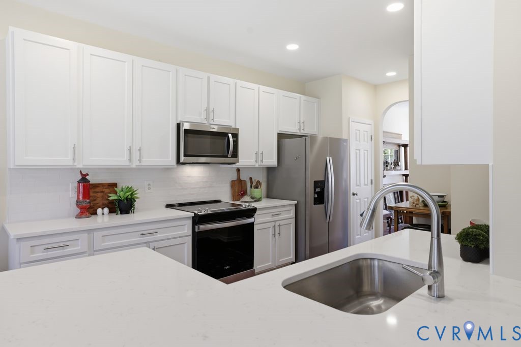 13924 Krim Point Road Midlothian, VA 23114 - Photo 8 of 48 a kitchen with a sink a refrigerator and cabinets