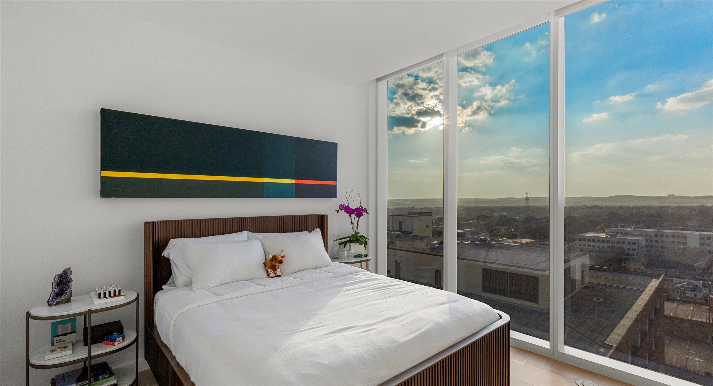 313 West 17th Street, Unit 1104 Austin, TX 78701 - Photo 37 of 40 Bright and versatile second bedroom with floor-to-ceiling windows that capture breathtaking sunsets over the Hill Country. A flexible space that easily transitions into a guest room, home office, or creative retreat.