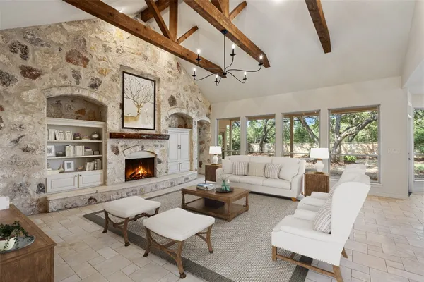 a living room with furniture a fireplace and a floor to ceiling window