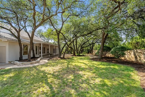 a view of a house with backyard and tree