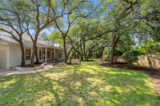 a view of a house with backyard and tree
