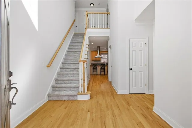 a view of a hallway with wooden floor and staircase
