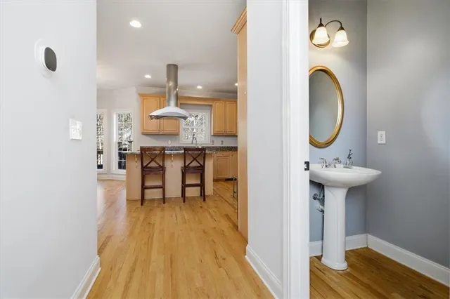 a dining room with wooden floor a chandelier a wooden table and chairs
