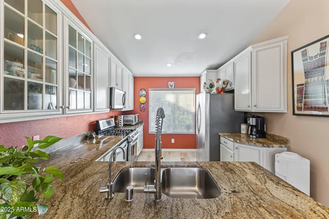 a kitchen with stainless steel appliances granite countertop sink stove and granite counter top
