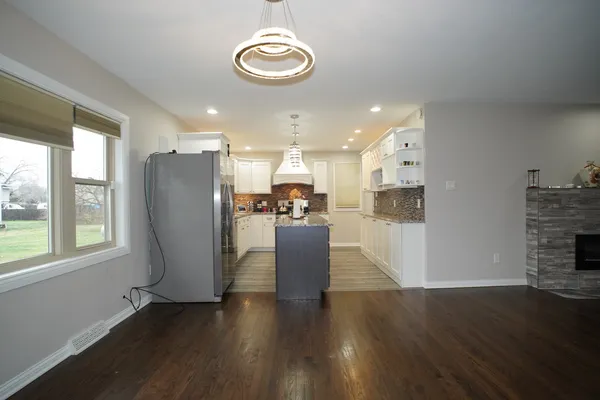 a view of kitchen with stainless steel appliances granite countertop a refrigerator a stove a microwave oven with wooden floor