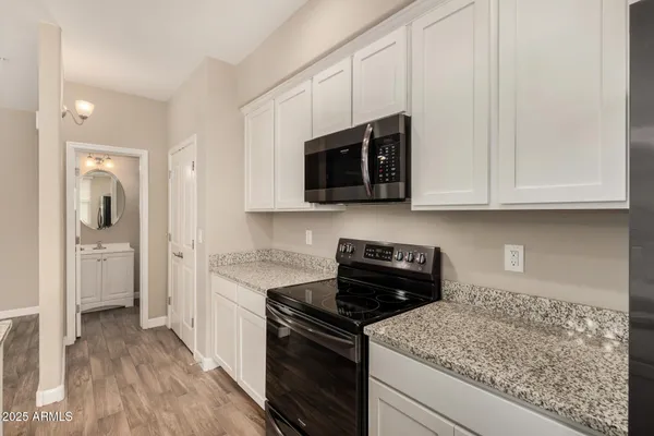 a kitchen with stainless steel appliances granite countertop a stove and a microwave