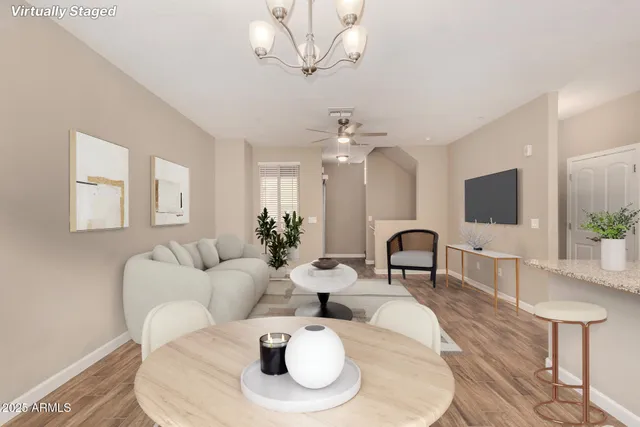 a living room with furniture a flat screen tv and a mirror