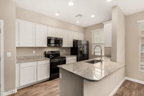 a kitchen with stainless steel appliances granite countertop a sink refrigerator and microwave
