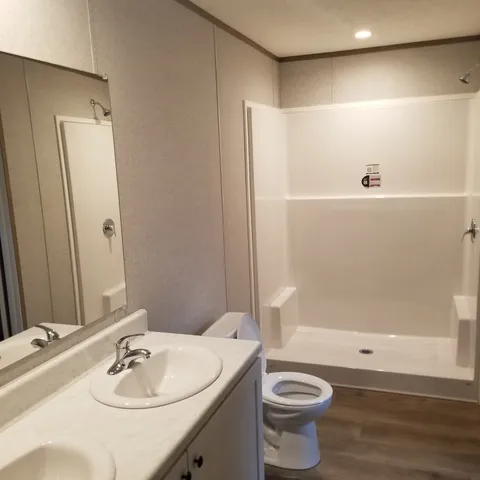 a bathroom with a sink a toilet and shower