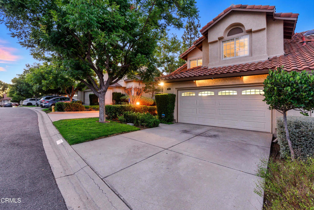 1095 Amberton Lane Thousand Oaks, CA 91320 - Photo 2 of 20 a front view of a house with a yard and garage
