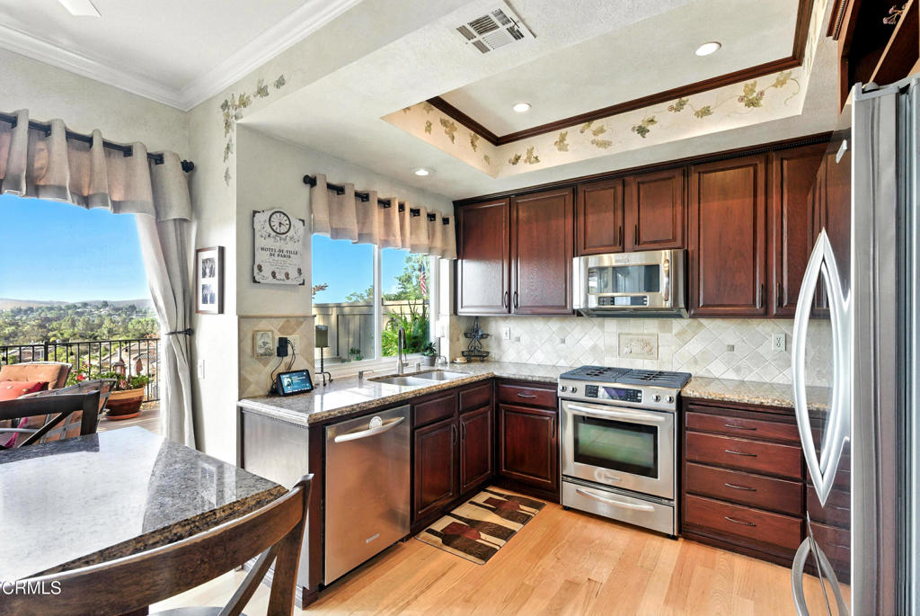 1095 Amberton Lane Thousand Oaks, CA 91320 - Photo 8 of 20 a kitchen with stainless steel appliances granite countertop a sink stove and refrigerator