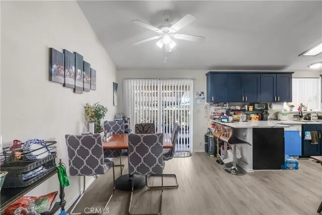 a open kitchen with stainless steel appliances granite countertop a stove top oven a dining table and chairs with wooden floor