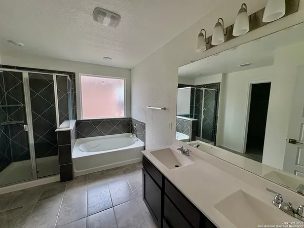 a bathroom with a tub sink and a mirror